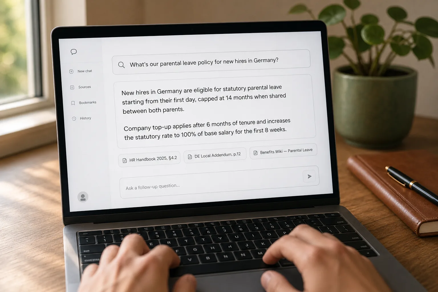 A laptop on a desk showing an internal chat interface answering an HR policy question with citations linking back to specific company documents.