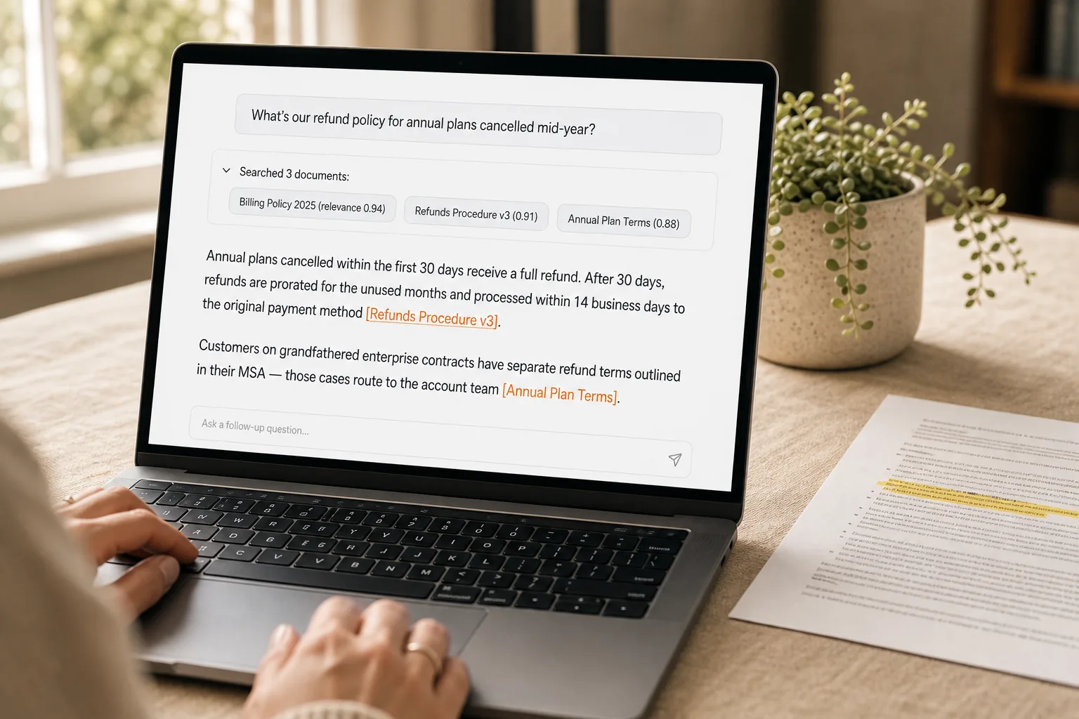 A laptop showing a chat interface where a question gets answered with three retrieved source documents shown above the answer and a clickable citation inline in the answer — illustrating how retrieval-augmented chat surfaces grounded, verifiable answers.