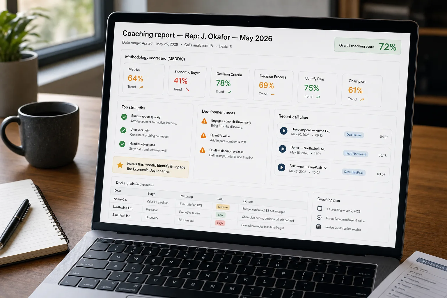 Over-the-shoulder photo of a laptop showing a generated monthly coaching report for a sales rep, with a MEDDIC adherence scorecard, strengths and development areas citing specific calls with timestamps, and deal-signal notes, on a tidy desk.